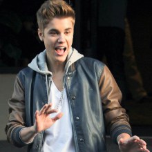 Justin Bieber is all smiles as he steps out of his hotel for a surprise meet and greet on Friday (Ju