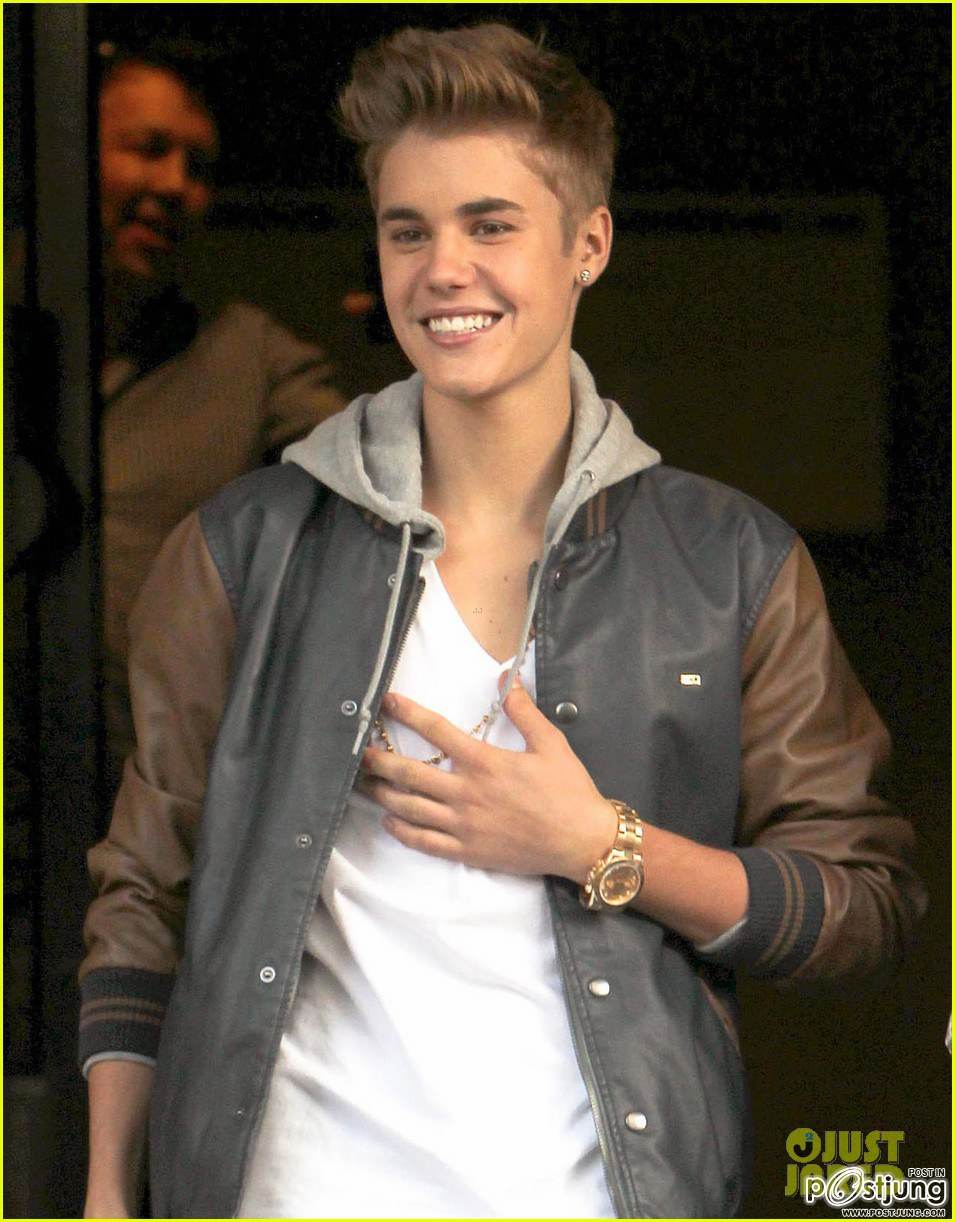 Justin Bieber is all smiles as he steps out of his hotel for a surprise meet and greet on Friday (Ju