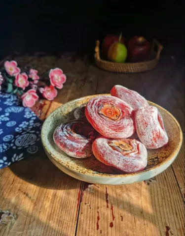 ซื่อปิ่ง (柿饼) - ลูกพลับที่ผ่านการปอกเปลือกและตากแห้งจนเนื้อนุ่มเหนียว มีรสหวานเข้มข้น ผิวด้านนอกมักมีผงสีขาวจากน้ำตาลที่ตกผลึกตามธรรมชาติ