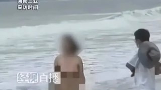 หญิงสาวเดินเปลือยกายบนหาดทราย ท่ามกลางสายตาของผู้คน