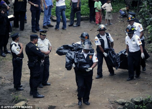 Volunteer firefighters carry some of the bodies of seven people killed by unidentified gunmen in the hamlet 'Las Escobas'