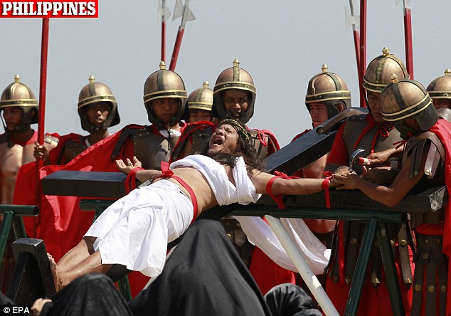 ความเจ็บปวดที่แท้จริง: ฟิลิปปินส์ที่นับถือศาสนาคริสต์ Ruben Enaje, 53, ตอกไปเป็นไม้กางเขนในช่วงออกกฎหมายของการตรึงกางเขนของพระเยซูคริสต์ในวันศุกร์ใน San Fernando, Pampanga จังหวัด