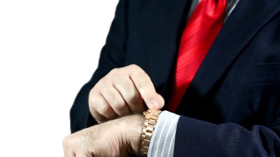 stock-footage-businessman-in-blue-suit-and-red-tie-wearing-a-golden-wrist-watch-checking-time-impatient-over-a
