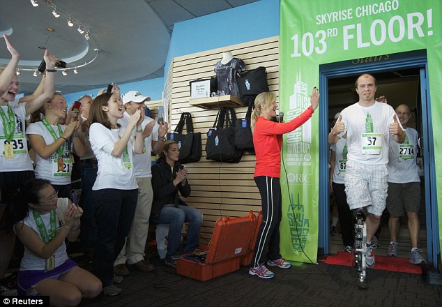 Mind blowing: Zac Vawter celebrates climbing to the top of the 103-story Willis Tower using the worlds first neural-controlled Bionic leg in Chicago