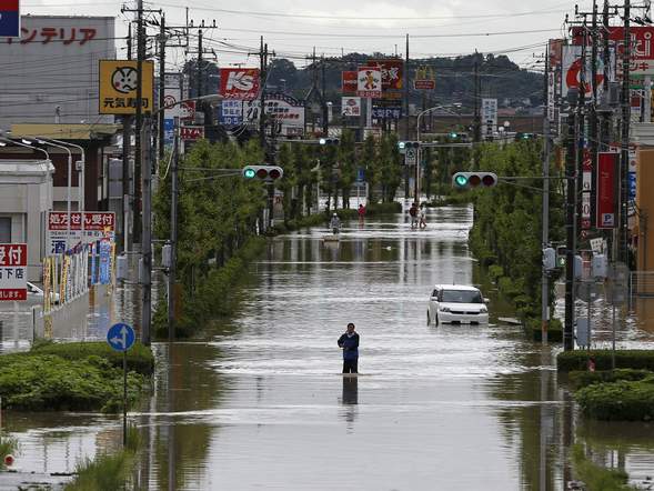 A man wades through floodwaters from the Kinugawa river, caused by typhoon Etau, in Joso