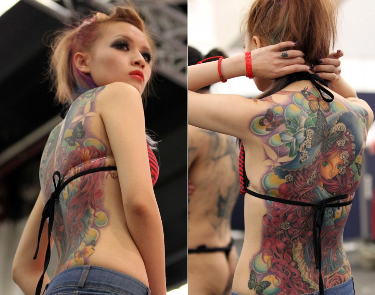 A woman from Asia shows her tattoo during the 21st International Tattoo Convention in Frankfurt, Germany, March 22, 2013.