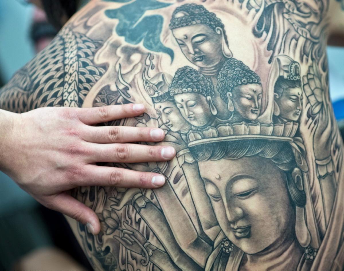 Several depictions of Buddha of different sizes decorate the back of a man at the International Tattoo Convention in Frankfurt am Main, Germany on March 23, 2013.